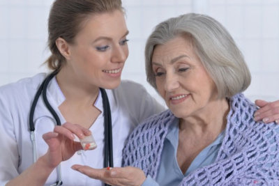 caregiver giving medicine to patient